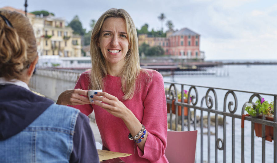 Foto von Elise, die in einem Café sitzt. Sie verwendet Luja female, um ihre mit MS verbundenen Blasensymptome zu behandeln.