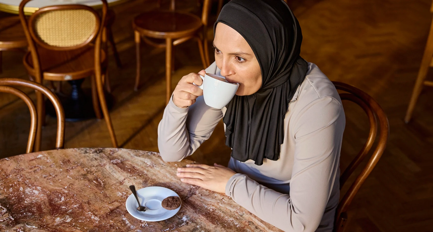 Foto von Fikria, die in einem Café sitzt. Fikria hat mit MS und Darmprobleme sind Teil ihres Lebens. Sie verwendet Peristeen Light, um ihre Symptome zu managen.