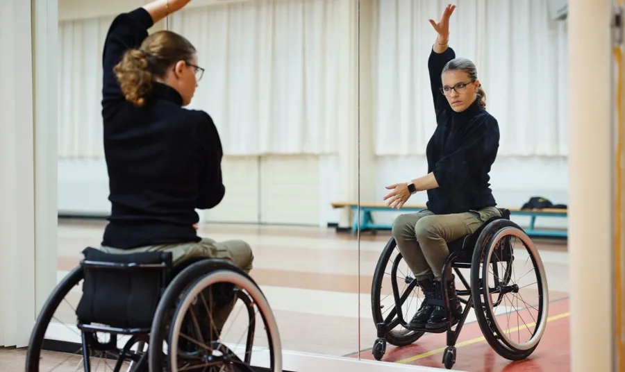 Foto von Marianne in ihrem Tanzstudio. Marianne hat das Rollstuhl-Tanzen für sich entdeckt und tanzt zusammen mit ihrem Tanzpartner Rumba, Paso Doble und Cha-Cha-Cha. 